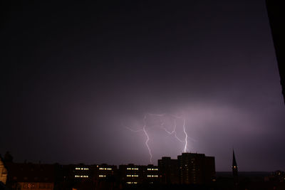 Illuminated cityscape against sky at night