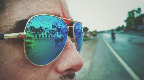 Close-up of man wearing sunglasses against clear sky