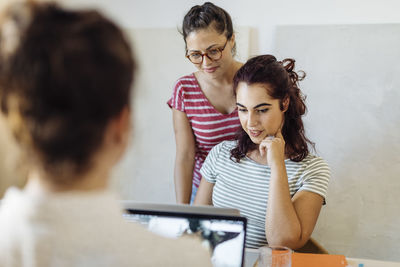 Young women working on laptop in light room