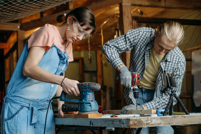 Man and woman working in workshop, doing furniture, reuse old materials to new product. awareness in