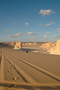 Sand dunes in desert against sky