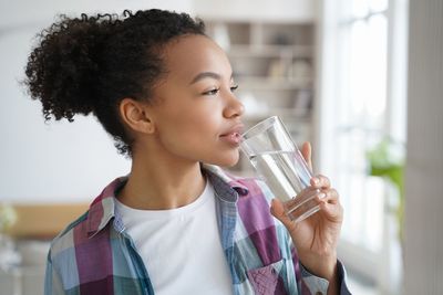 Young woman using mobile phone while sitting at home