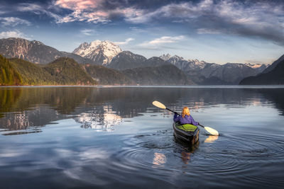 Reflection of person in lake against sky