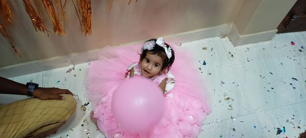 High angle view portrait of cute girl with pink balloons