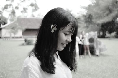 Close-up of smiling woman looking down on field