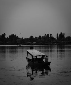 Man in boat on river against clear sky
