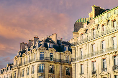 Low angle view of buildings against cloudy sky