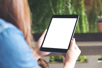 Midsection of woman using digital tablet outdoors