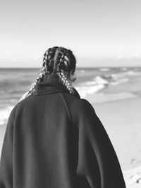 Rear view of woman looking at sea shore against sky