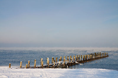 View of jetty at calm sea against clear sky