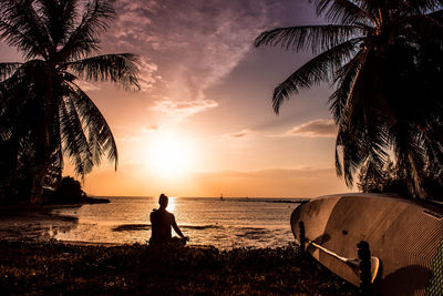 Silhouette people on beach against sky during sunset