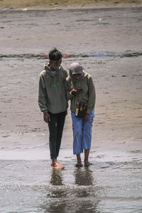 Rear view of man standing at beach