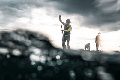 Man paddleboarding on sea against sky