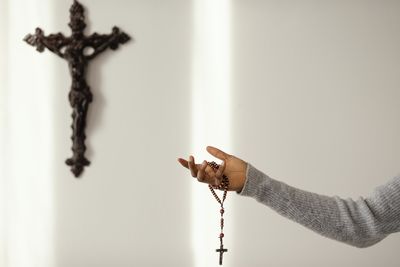 Cropped hand of woman holding rosary beads