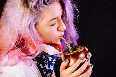 Close-up of young woman drinking coffee at home