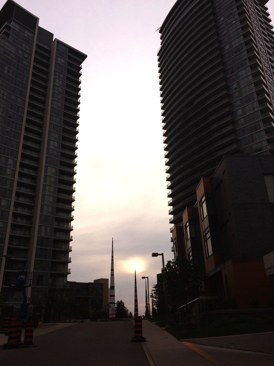 building exterior, architecture, built structure, city, street, outdoors, skyscraper, street light, sunset, sky, road, travel destinations, no people, modern, day