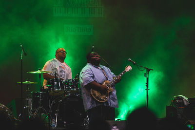People playing guitar at music concert