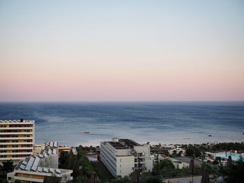 High angle view of buildings by sea against clear sky