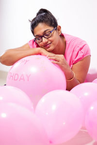 Portrait of young man with pink balloons