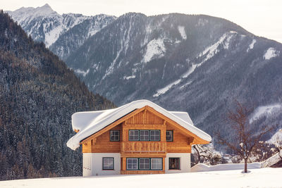 Houses on snow covered mountain against sky