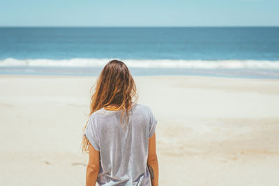 Rear view of woman standing on beach