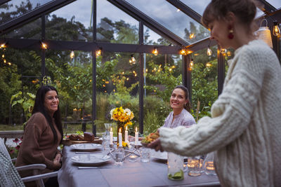 Smiling female friends in greenhouse