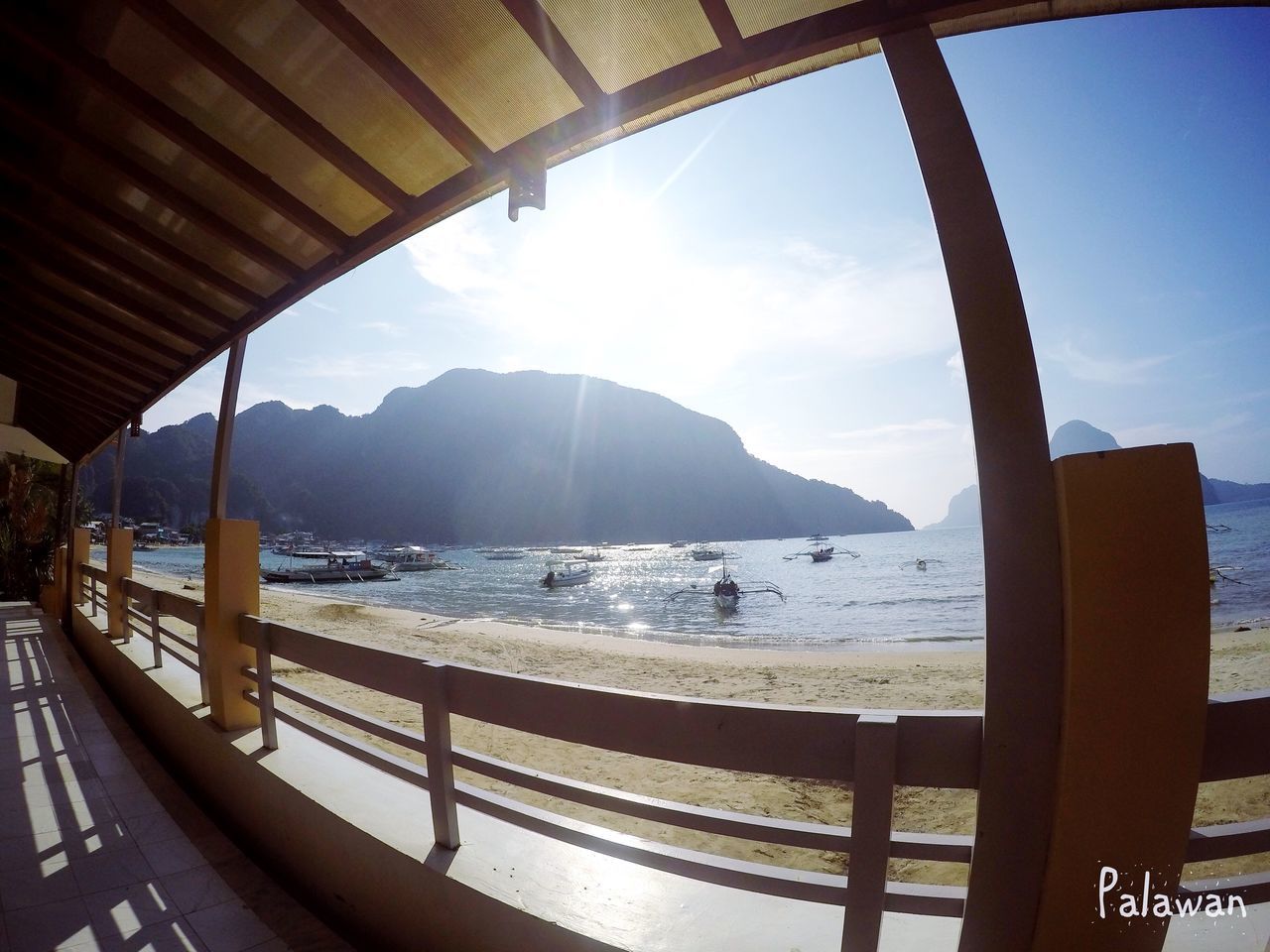 water, sea, mountain, built structure, sky, railing, architecture, indoors, sunlight, scenics, nature, tranquility, beauty in nature, horizon over water, tranquil scene, pier, mountain range, day, window, idyllic