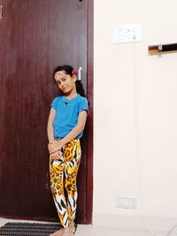 Portrait of boy standing against wall