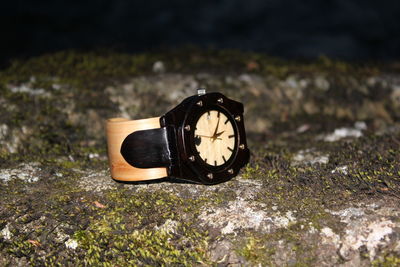 Close-up of wristwatch on rock