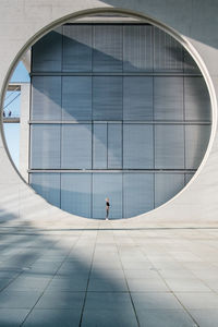 Woman standing on circle against building