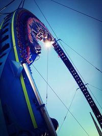 Low angle view of ferris wheel against blue sky