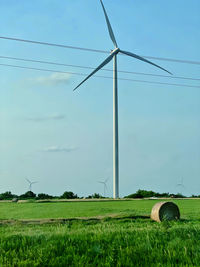 A wind turbine looking over a field in kansas.