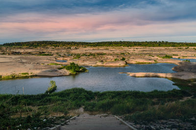 Scenic view of river against sky during sunset