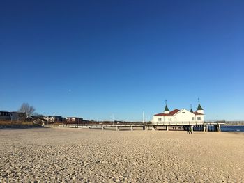 Built structure on beach against clear blue sky