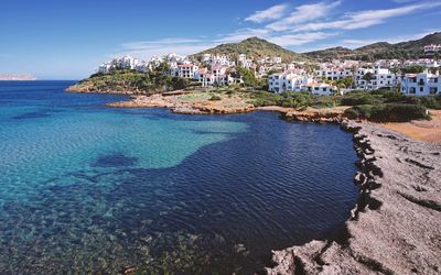 Scenic view of sea by town against sky