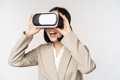 Young woman using vr headset against white background
