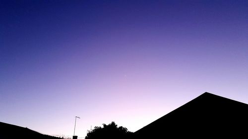 Low angle view of silhouette built structure against blue sky