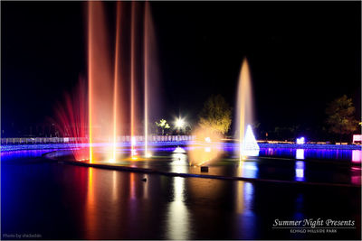 Illuminated bridge over river at night