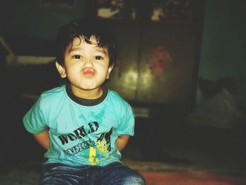 Portrait of cute toddler boy puckering at home