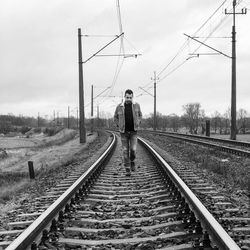 Rear view of man standing on railroad track