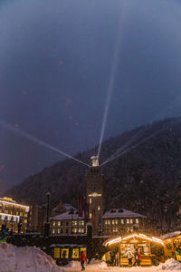 Illuminated buildings in city against sky at night