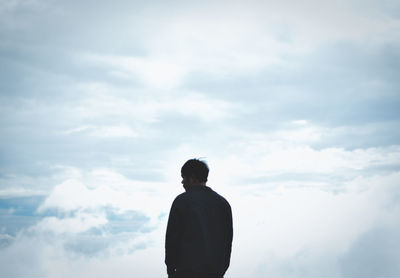 Rear view of silhouette man standing against sky