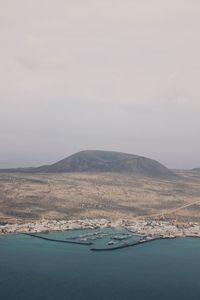 Scenic view of sea and mountain against sky