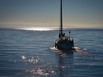 Boat sailing in sea at sunset