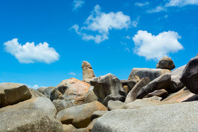 Rocks on beach against blue sky