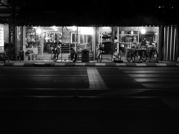 People walking on illuminated city at night