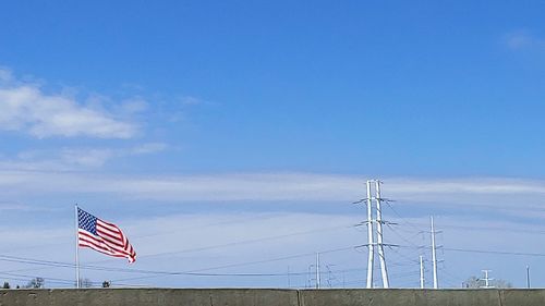 Low angle view of flag against blue sky