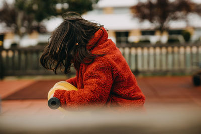 Child with red jacket playing in the park