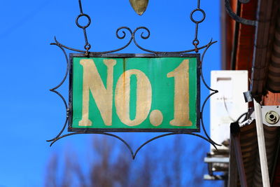 Low angle view of road sign against blue sky