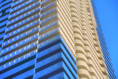 Low angle view of modern building against clear blue sky